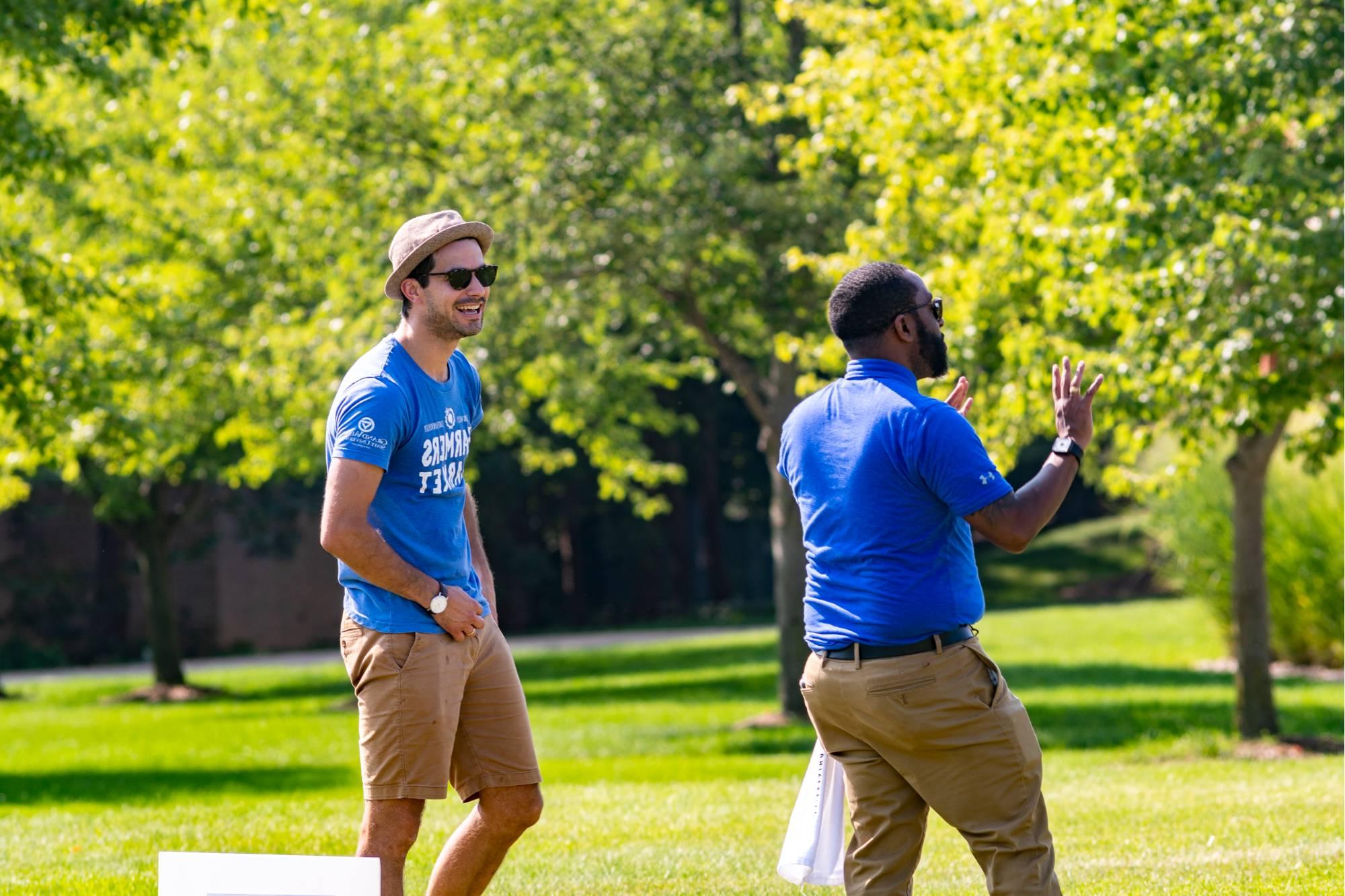 Alex Priebe laughing with a colleague at the first ever GVSU cornhole tournament for employees